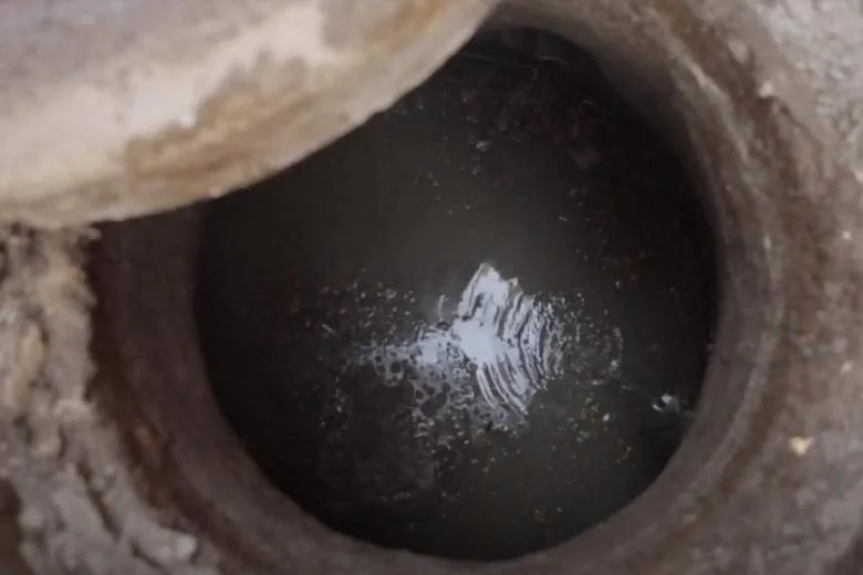 A cesspit bubbling with toxic fumes. Sewer cleaners are sometimes forced to physically enter these holes to unclog the sewerage system. Photo: Arvind Dev.
