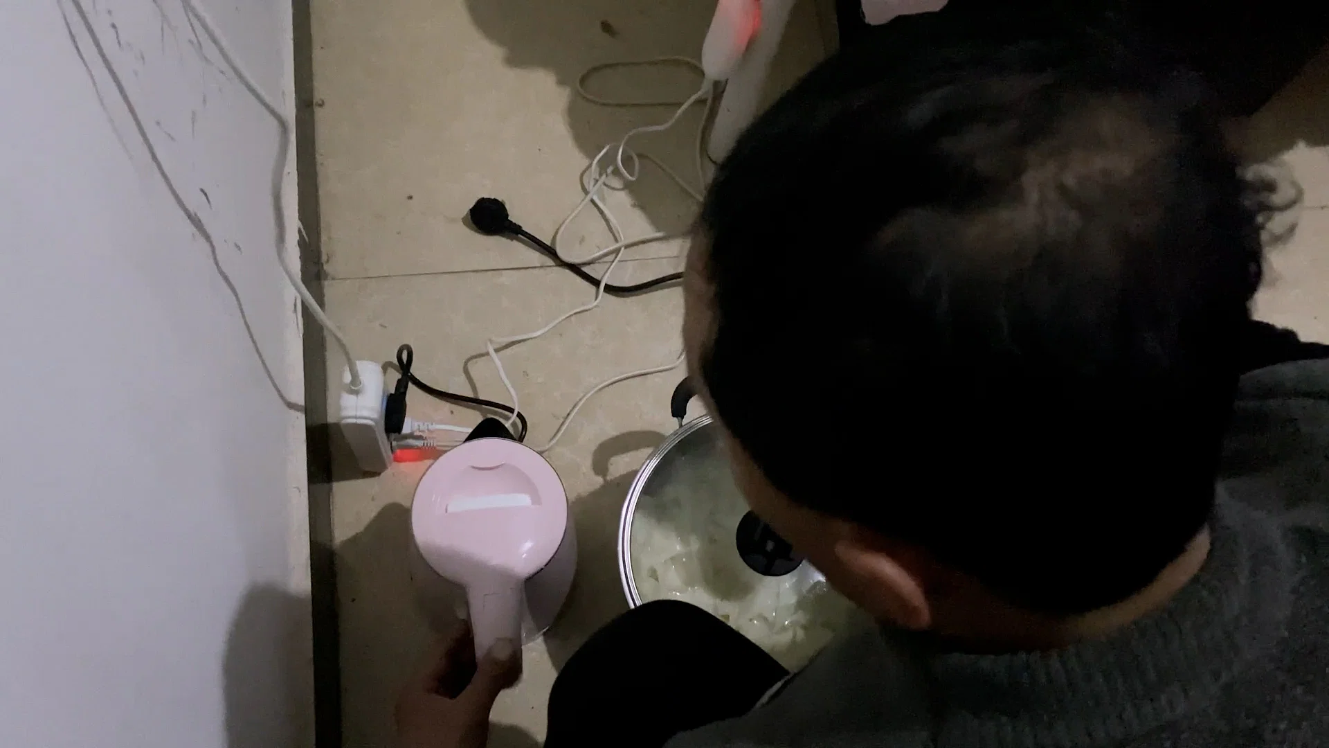 Mr Wei boils water and prepares his meals on the floor of his room in the dormitory. Photo: Danson Cheong.