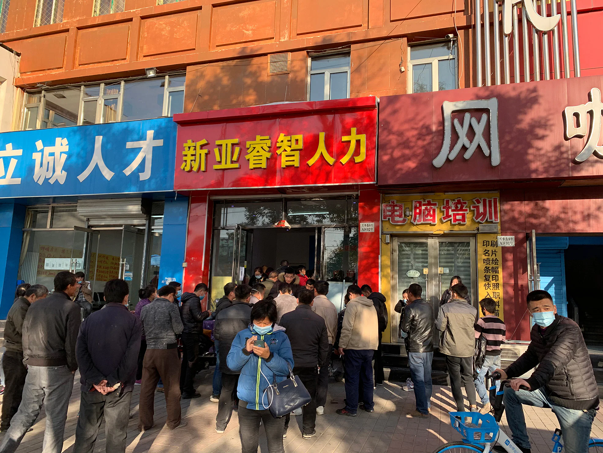 Rural migrants gather outside a labour agency at the Majuqiao market to apply for the temporary jobs on offer. Photo: Danson Cheong.